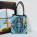 Detail of blue and black geometric knit tote bag with durable woven texture and black straps - New Chinese Blue
