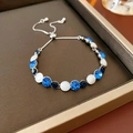 Détail du bracelet argenté réglable avec cristaux bleus et blancs sur plateau à bijoux - Bleu