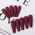 Detailed view of matte wine red press-on nails in coffin shape displayed on paper - Cherry Red