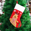 Red knitted Christmas stocking with 3D reindeer pattern hanging on a Christmas tree - Reindeer