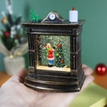 Palla di neve natalizia a forma di camino con glitter e scena festiva nella mano - Albero di Natale del Camino