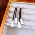 Detalle de pendientes largos de borla de cuero marrón con detalles en plata mate - Estilo de Pendent de Plata Mate / Plateado