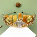 Silver crown headband with metal bees, roses, and orange natural stone beads on a stand - Red Aventurine