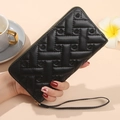 Classic black quilted wallet with heart embroidery and golden zip closure in hand - Black