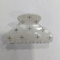 Vue détaillée de la pince à cheveux nacrée blanche avec motifs étoiles en strass argentés - 6cm / Blanc