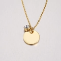 Macro shot of a gold-plated circular pendant with a sparkling clear zircon on a fine chain - 4# Birthstone