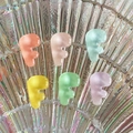 Close-up of matte resin F-shaped letter charms in vibrant colors on a glass shell - Letter F