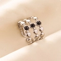 Dettaglio anello in acciaio argento con tre pietre nere su tessuto di seta - Triplo Strato con Perline / Argento Nero