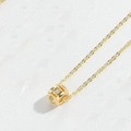 Close-up of a gold necklace featuring a hollow cubic pendant inlaid with white zircon - Square Zircon