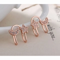 Détail de boucles d'oreilles étoile et lune or rose avec cristaux sur céramique blanche - Clips d'Oreilles Lune et Étoile - Or Rose