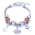 Detail of silver charm bracelet with crown, heart lock and orange rhinestones - Brown