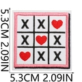 Macro shot of embroidered Valentine tic-tac-toe patch with red heart and black X pattern - No.23-Heart Tic-Tac-Toe