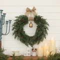 Christmas wreath with pine cones and linen bow hanging on a white wooden wall decor - 50cm x 40cm x 10cm