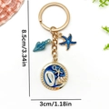 Gold ocean keychain with blue starfish and shell pendants on white background - Blue Enamel Starfish Conch Style (ER1924)