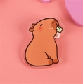 Cute acrylic capybara badge pin with orange-brown finish on a soft pink background - No.6 Capybara