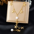 Goldene Y-Halskette mit Seestern-Anhängern und weißen Perlen auf einer Schmuckbox - Goldener Seestern-Perlen-Stil (N3540)