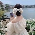 Elegant large beige satin bow hair clip accessory worn on back of head with white ribbon - Milk White Bow Spring Clip (Satin)