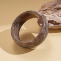 Détail d'un large bracelet en résine marron marbré avec textures fumées rétro - Gris