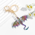 Detailed macro view of an iridescent dragon keychain with sparkling crystal rhinestones - Multicolor