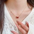 Gros plan d'un collier doré avec pendentif animal rouge et bords perlés sur un mannequin - Or-Rouge