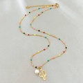 Goldene Halskette mit bunten Perlen, weißer Perle und Kaktus-Anhänger auf grauem Grund - Kaktus-Stil