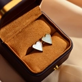 Macro-opname van vergulde hartoorbellen met parelmoer in een luxe geschenkdoos - Wit