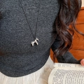 Detail of silver pony pendant necklace on model wearing dark knit sweater and beige skirt - 18# Necklace Silver Black Cord Pony