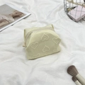 Detail of beige heart-embossed cosmetic bag with smooth zipper and portable strap - Yellow