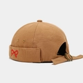 Detail of khaki Docker hat featuring red bow embroidery and adjustable metal buckle strap - Caramel color