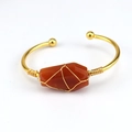 Handmade gold wire wrapped open bangle featuring a raw hexagonal carnelian gemstone - Red Agate