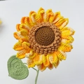 Detailaufnahme handgehäkelter Sonnenblume mit gelb-orangen Blättern und grünem Blatt - Große Sonnenblume (S-Stil)