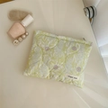 Macro detail of quilted floral makeup bag with light green and pink flower patterns - Green Leaf Purple Floral