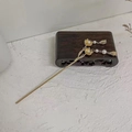 Detail of golden magnolia hairpin with pearls and delicate tassel on a wooden base - Small KC Gold Lotus