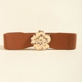 Macro detail of brown elastic waist belt featuring a shiny gold floral metal buckle - Camel