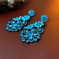 Dettaglio degli orecchini vintage a fiore con cristalli blu su sfondo in pelle marrone - Perno in argento-Blu