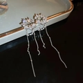 Detalle macro de pendientes de borla plateados con hojas brillantes y perlas - Borla de Circonita con Flores Plateadas (Clip de oreja)