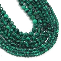 Macro detail of faceted green malachite beads showing natural black stripe textures - Malachite