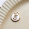 Macro detail of gold plated letter S pendant with white shell and inlaid zircons - S Round