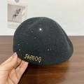 Detalle de boina de chenilla negra con lentejuelas plateadas y logo metálico dorado - Negro