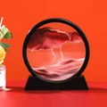 Close-up of a circular sand art piece with red and black sand in a glass frame - 7 Inch Round Red