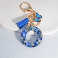 Royal blue resin letter O keychain with elegant tassel and butterfly charm accents - Letter O