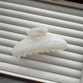 Close-up of ink-painted cream marble hair claw clip on beige velvet display tray - White Semicircle 11cm