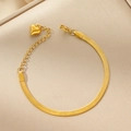 Primer plano de un colgante de corazón dorado en una pulsera de cadena de serpiente - Pulsera / Dorado