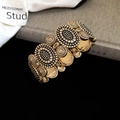 Dettaglio di bracciale vintage dorato con rilievo floreale e motivi a raggio di sole - Stile Motivo a Sole in Rilievo / Oro-Rotondo