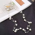 Lunga collana di perle a strati con catena d'argento su sfondo di rivista - Perla Bianca + Catena Argentea