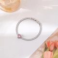 Detail van een hartvormige roze zirkoon op een zilveren tennisarmband met stenen - Zilveren Hartstijl