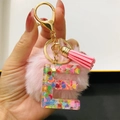 Pink keychain featuring resin letter E with colorful heart sequins and pompom - Letter E