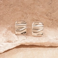Macro detail of silver geometric earrings with wavy texture on a natural stone background - Steel Pin - Silver Square