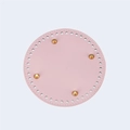 Macro view of pink round PU leather bag base with golden feet and pre-punched holes - Pink