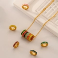 Golden chain necklace with colorful enamel rings and textured metal beads on a beige backdrop - Multicolor 7-Ring Necklace